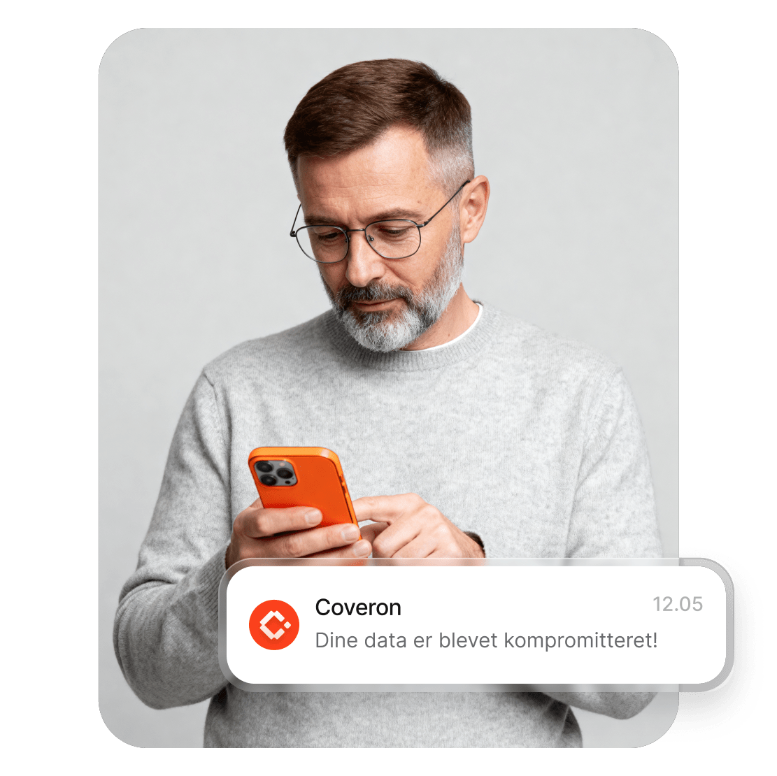 En mand, der bruger en smartphone til at læse Coverons advarsel om, at hans data er blevet kompromitteret.