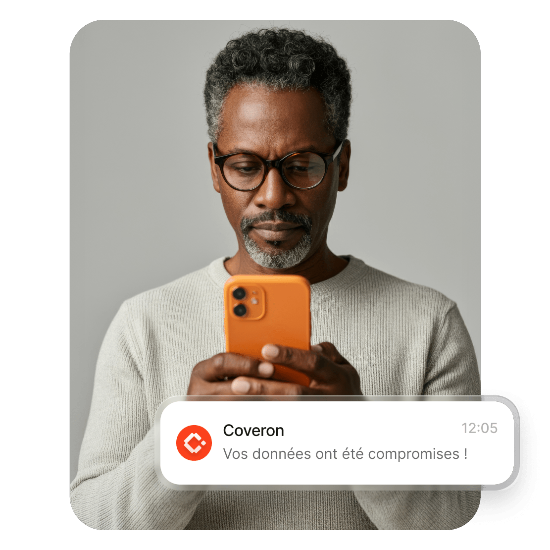 Un homme utilise son smartphone pour lire l’alerte de Coveron l’informant que ses données ont été compromises.