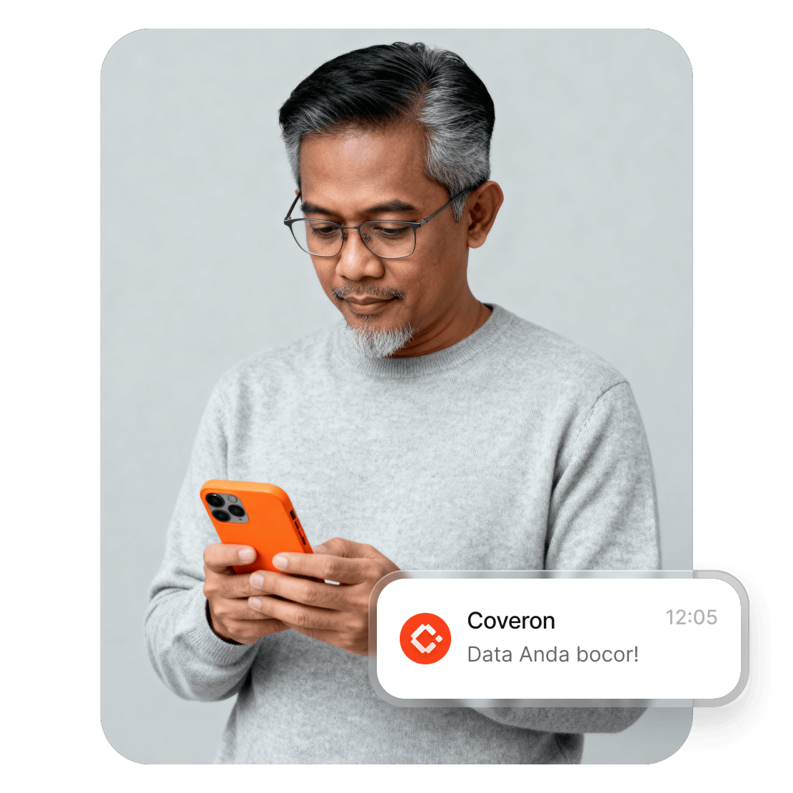 Seorang pria membaca peringatan dari Coveron di ponsel mengenai kebocoran data pribadinya.
