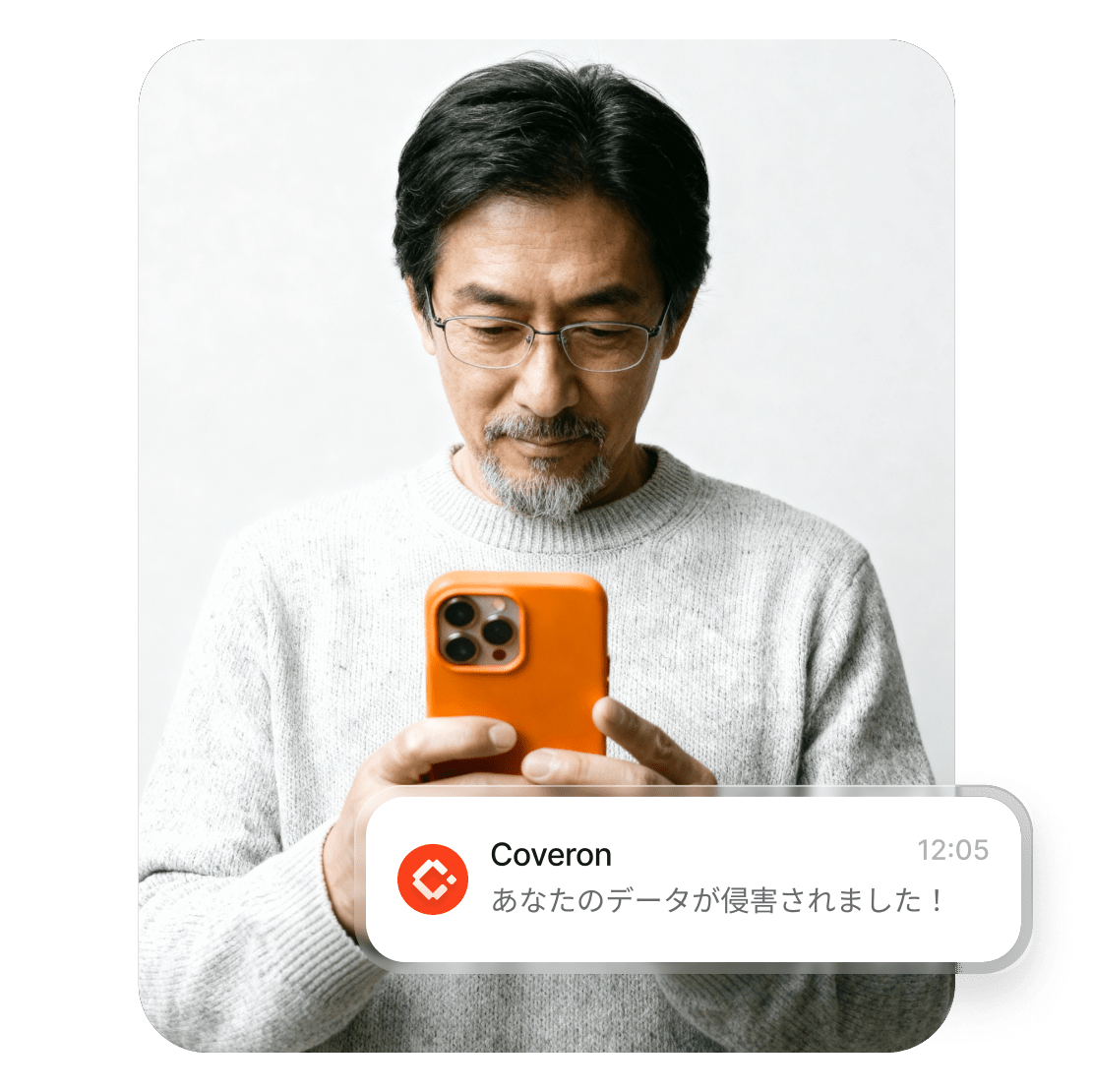 スマートフォンで、自分のデータが侵害されたというCoveronからの警告を読んでいる男性。