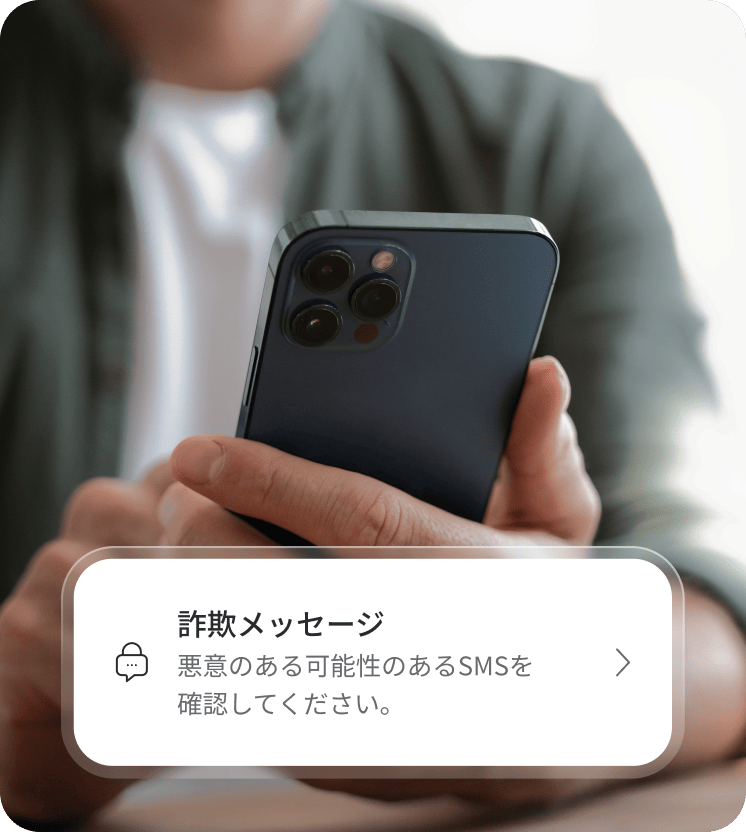 スマートフォンを使って詐欺の可能性があるメッセージを確認している人。