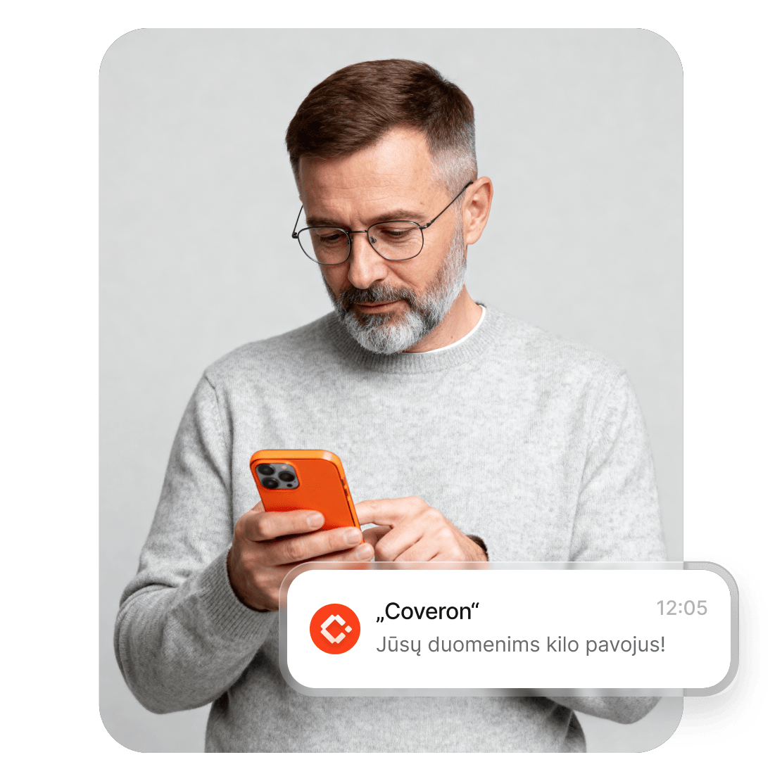 Vyras išmaniajame telefone skaito „Coveron“ įspėjimą, kad jo duomenims kilo pavojus.
