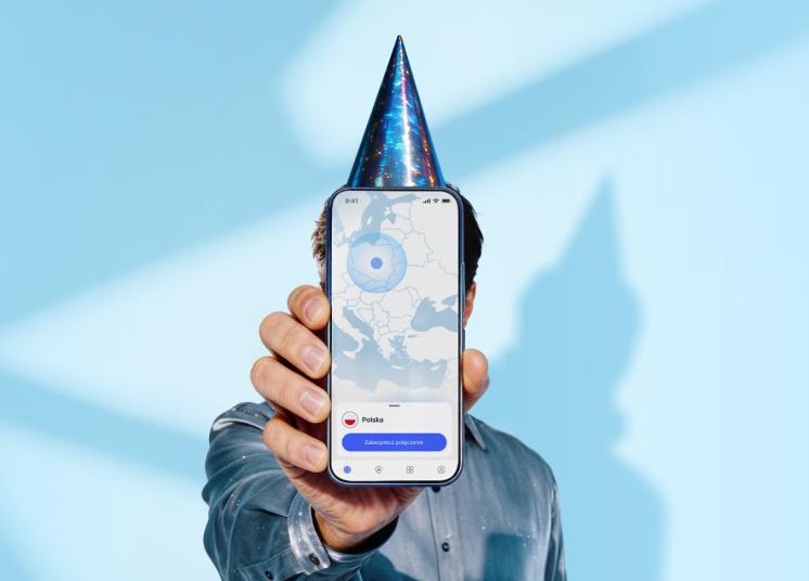 Osoba w czapeczce urodzinowej trzymająca smartfon, na którym wyświetla się główny ekran aplikacji NordVPN.