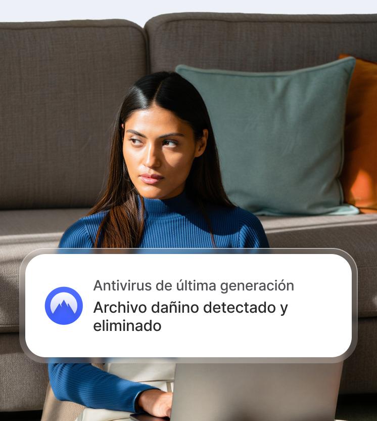 Una mujer en una laptop con una notificación del antivirus de última generación que muestra que se ha detectado y eliminado un archivo peligroso.