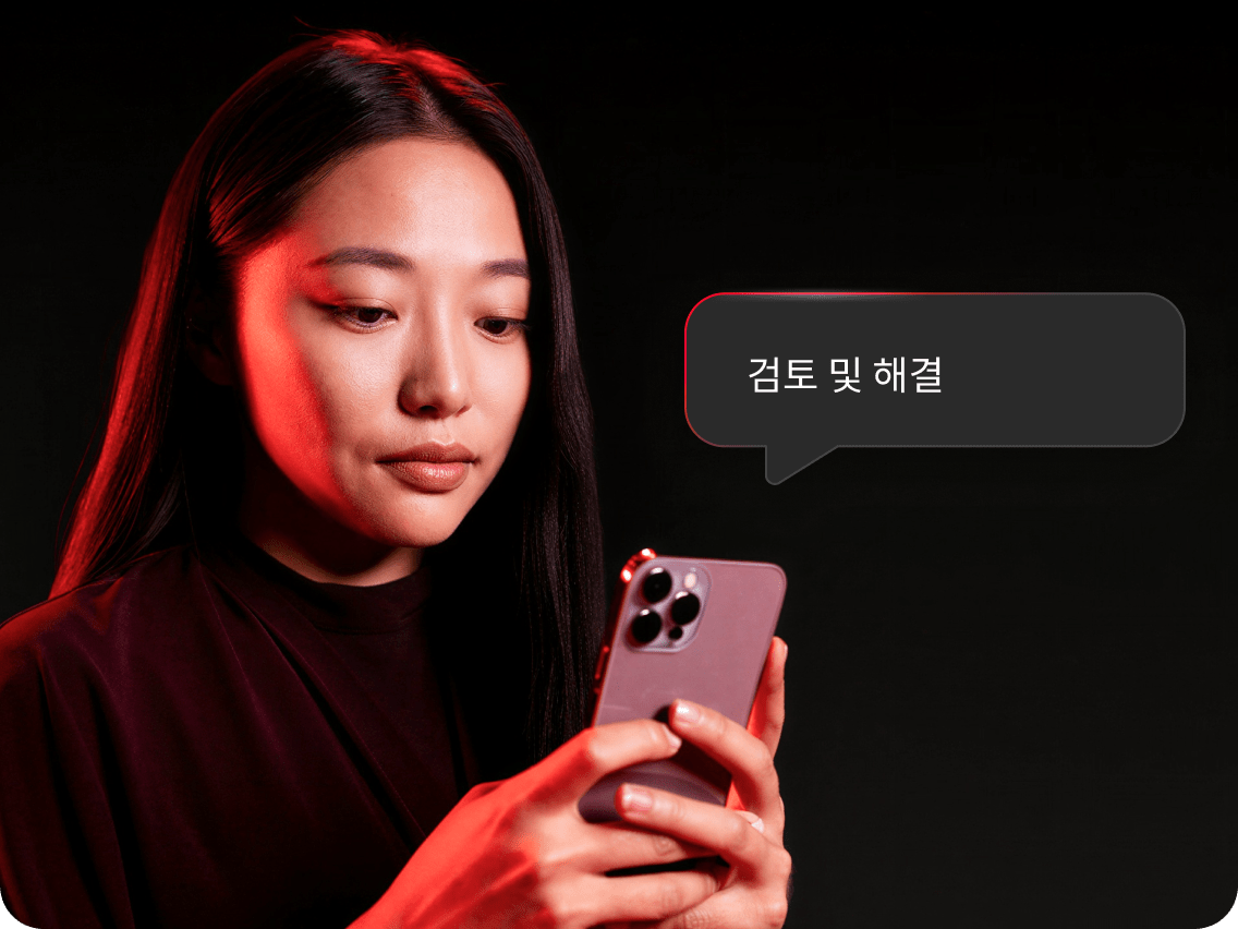 휴대폰으로 다크 웹 모니터링 알림을 확인하며 문제를 해결할 준비를 하고 있는 여성.