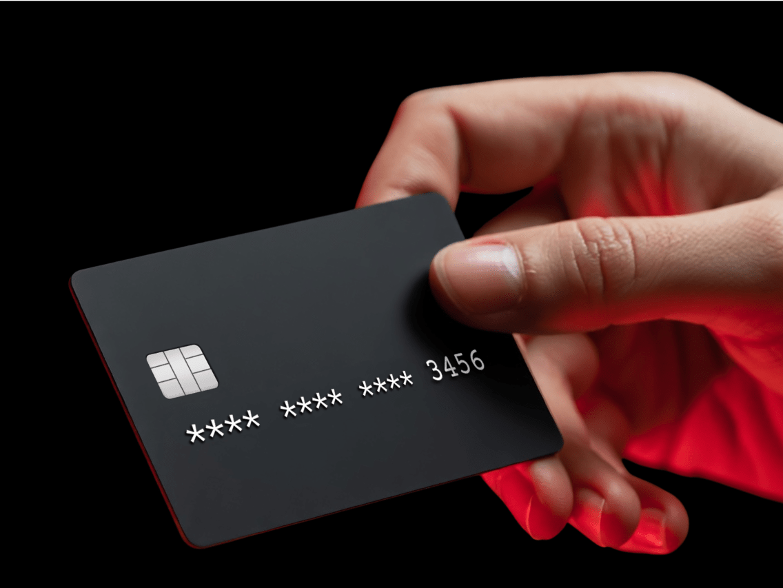 Eine Hand, die eine Kreditkarte hält, was Kriminelle darstellt, die Finanzinformationen aus dem Dark Web beziehen.