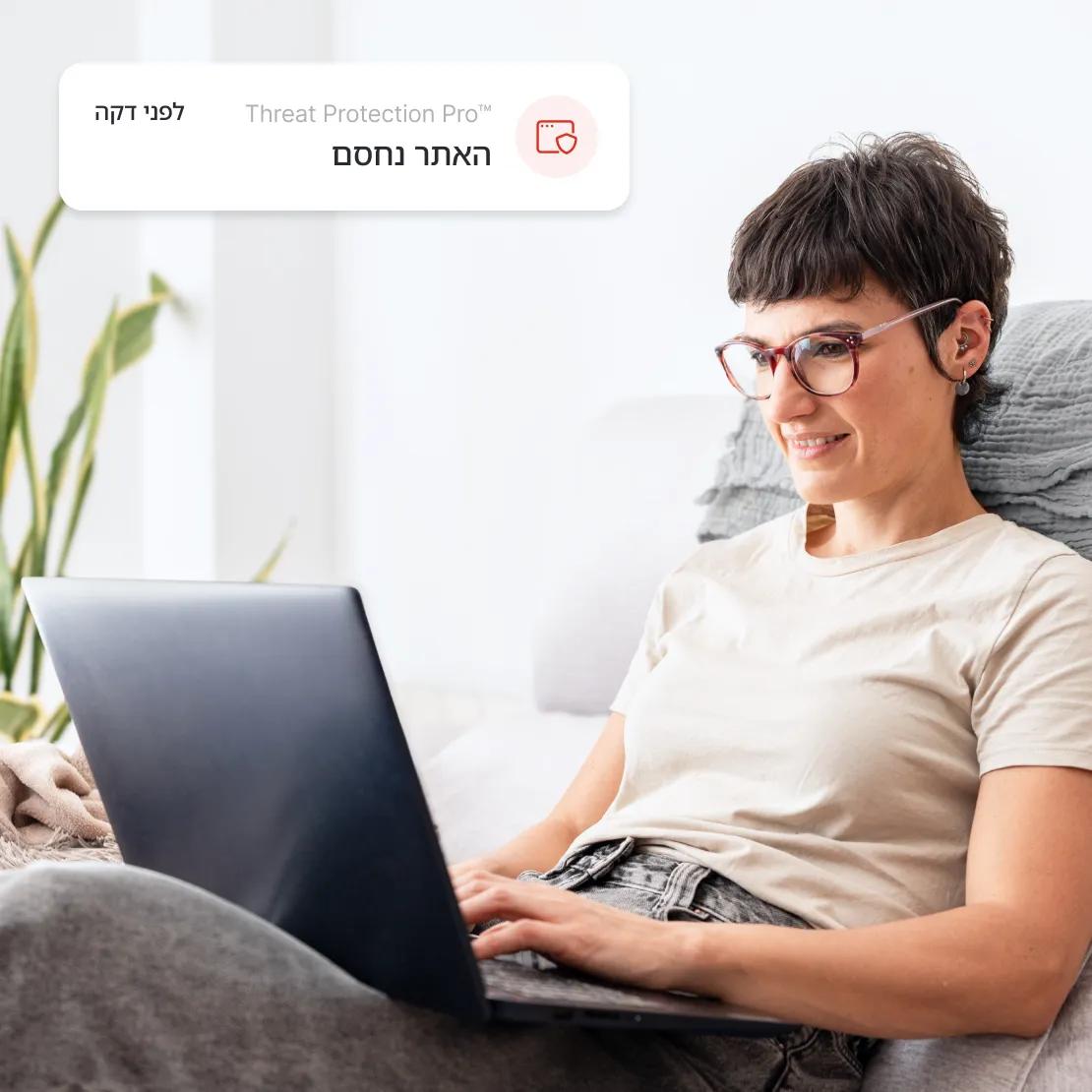 אישה נהנית מגלישה בטוחה יותר עם ™Threat Protection Pro החוסמת אתרים זדוניים.