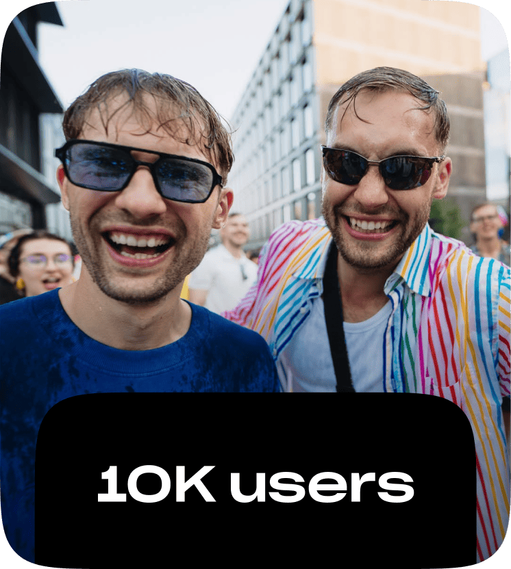 Two colleagues laughing together at an outdoor city event, captioned 10K users.