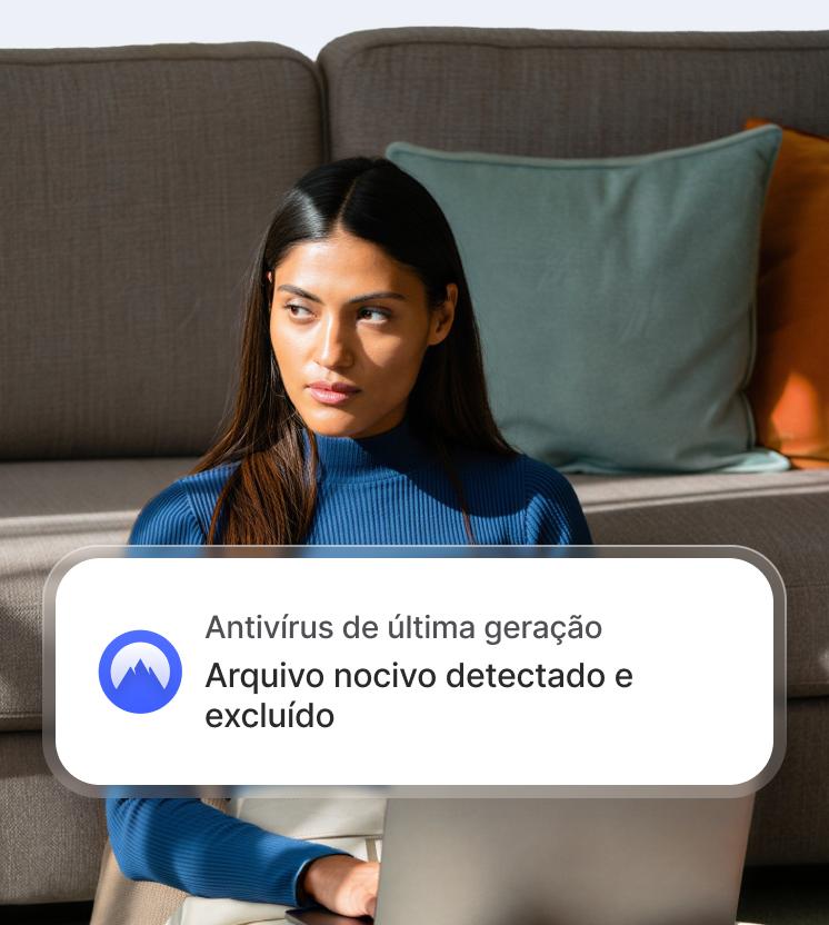 Uma mulher em um notebook com um alerta de antivírus de última geração mostrando que um arquivo malicioso foi detectado e excluído.