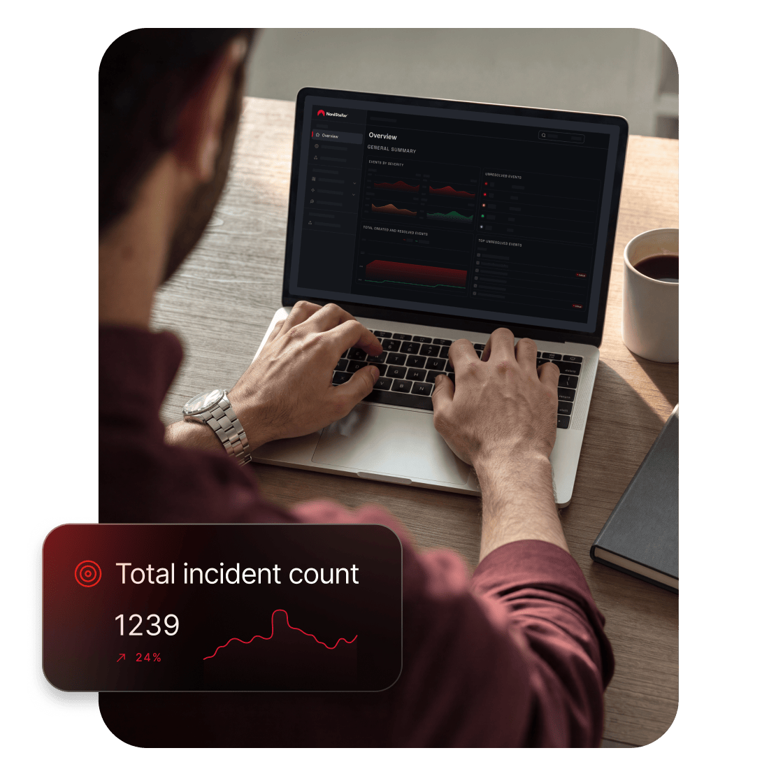Una persona seduta a una scrivania con un laptop aperto, che controlla gli avvisi di minacce nell'app NordStellar.
