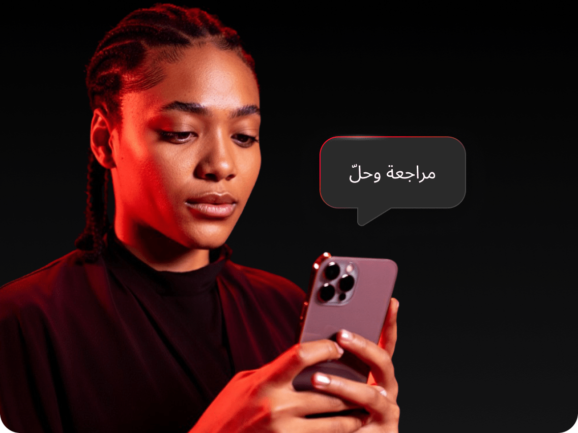 امرأة تستعرض تنبيه Dark Web Monitor على هاتفها، وتستعد لحل المشكلة.