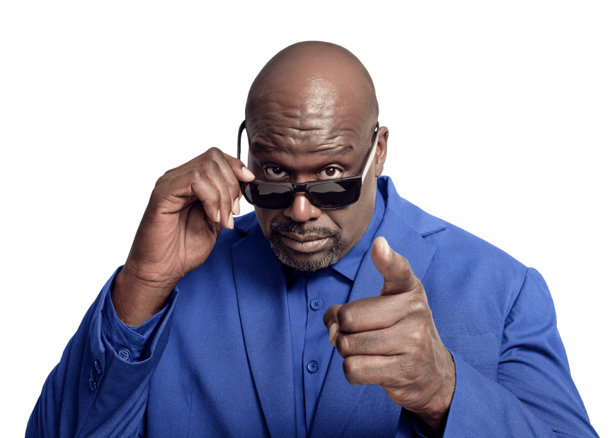 Shaquille O'Neal looking over his sunglasses and pointing at the camera.