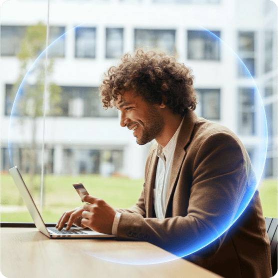 Man holding a credit card and using a laptop to browse more securely with a VPN
