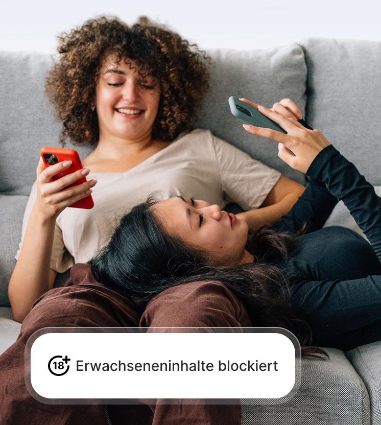 Zwei Frauen nutzen ihre Handys auf sichere Weise, da der Schutz vor Betrug und Phishing Websites für Erwachseneninhalte blockiert.