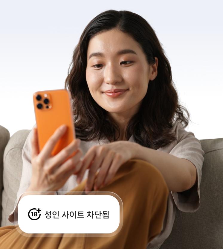 성인 사이트를 차단하는 스캠 및 피싱 방지 기능을 통해 안전하게 휴대전화를 사용하는 여성.
