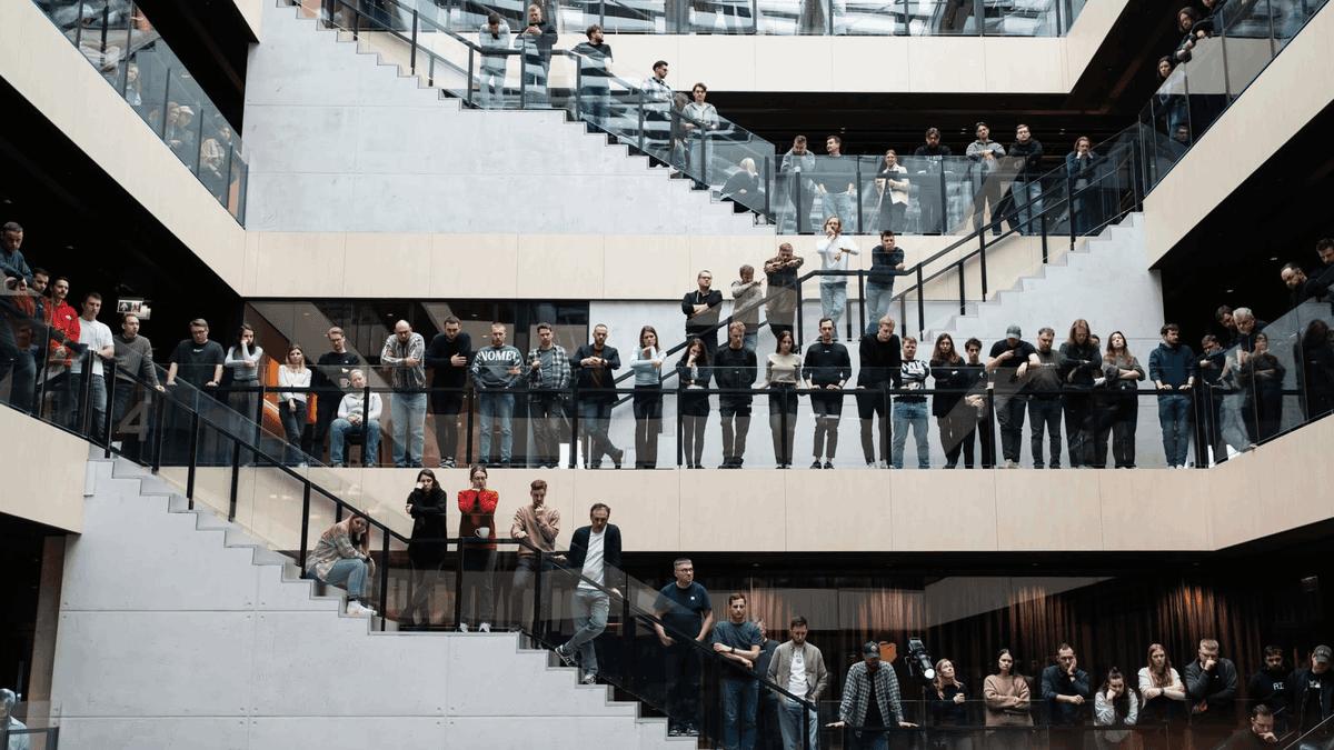 Nord Security employees lining the balconies and stairs of the office atrium.