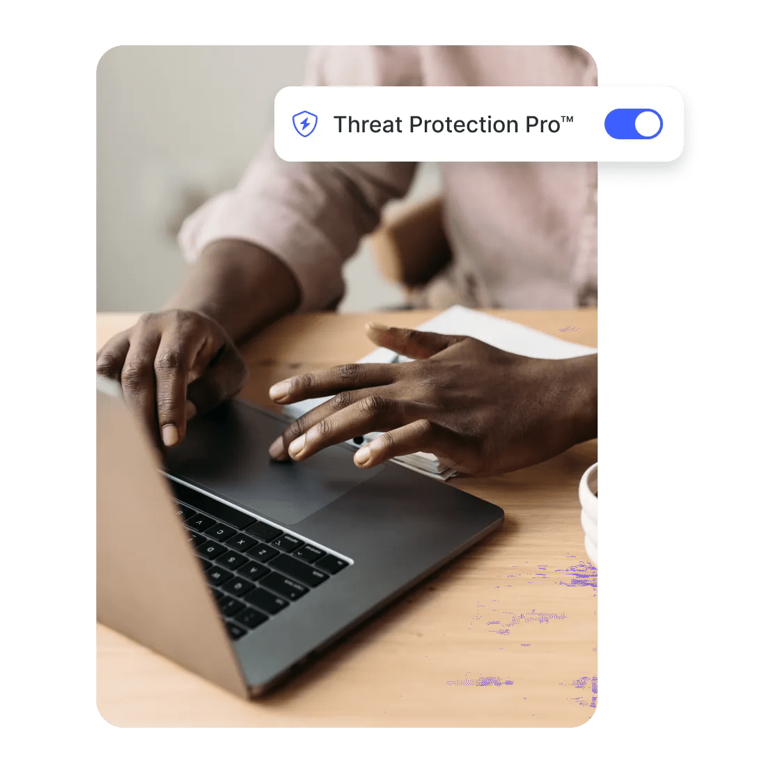 Bir adam dizüstü bilgisayarında Threat Protection Pro özelliği etkinken güvenli şekilde geziniyor.