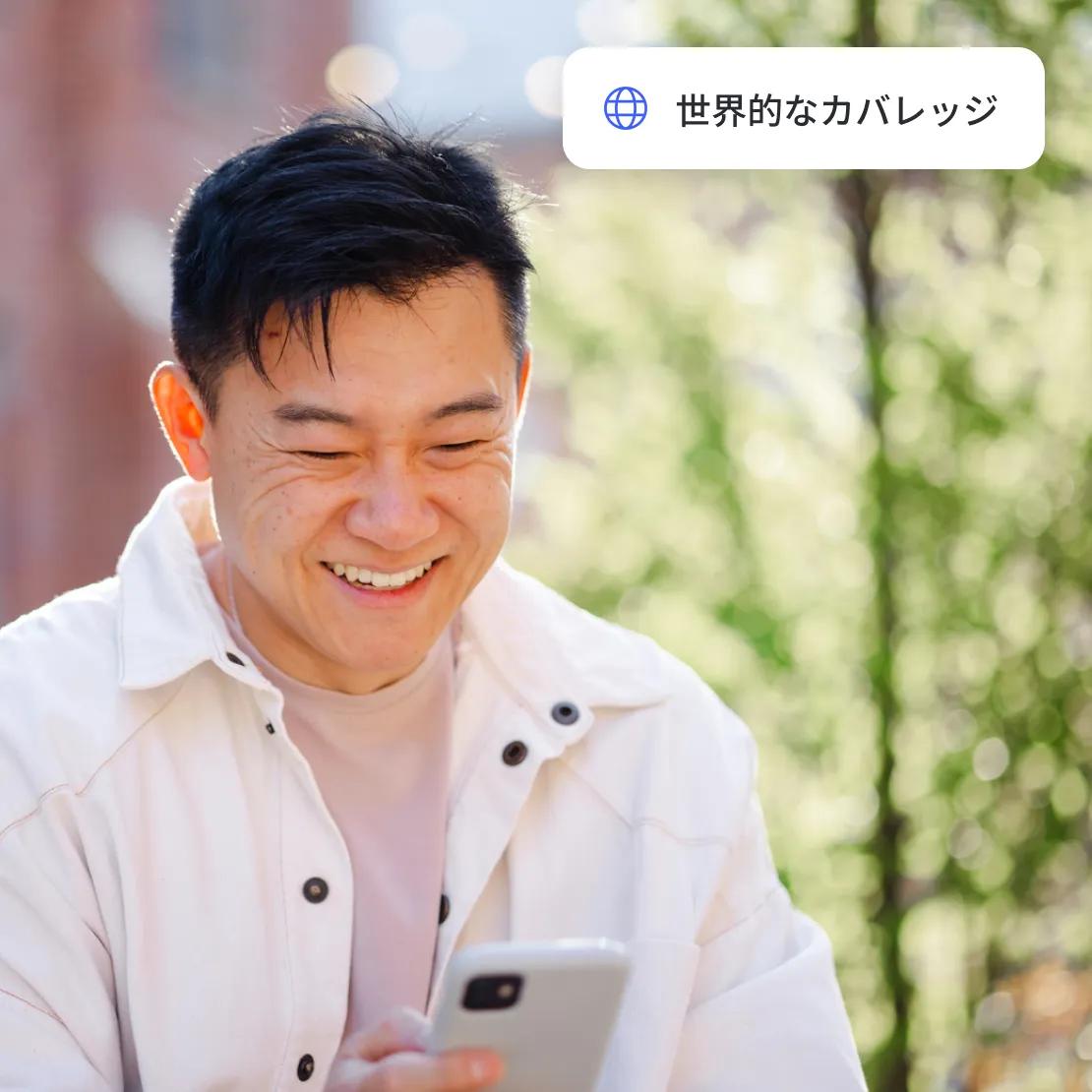 スマートフォンでグローバルなVPNサービスを利用している男性。