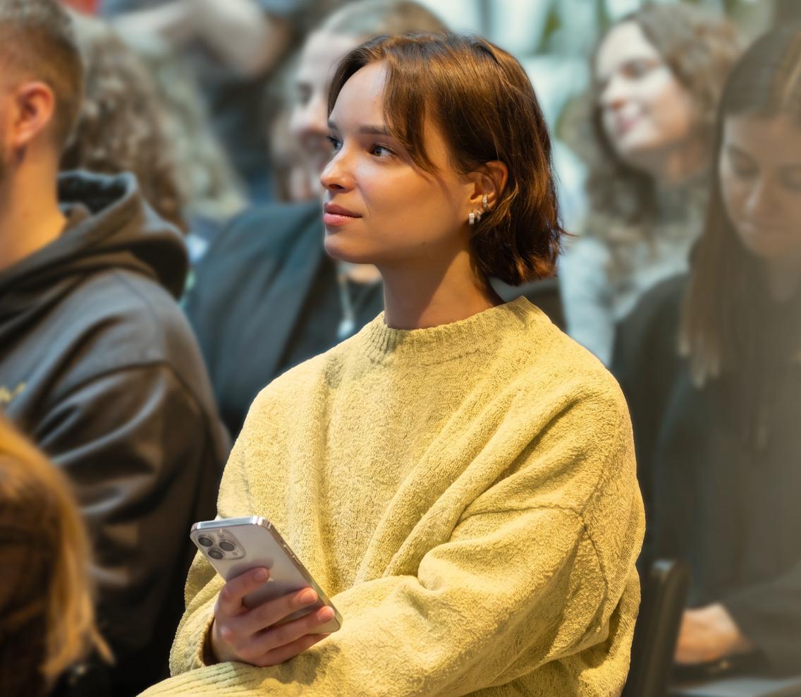 Nord Security employee listening attentively at a company event.