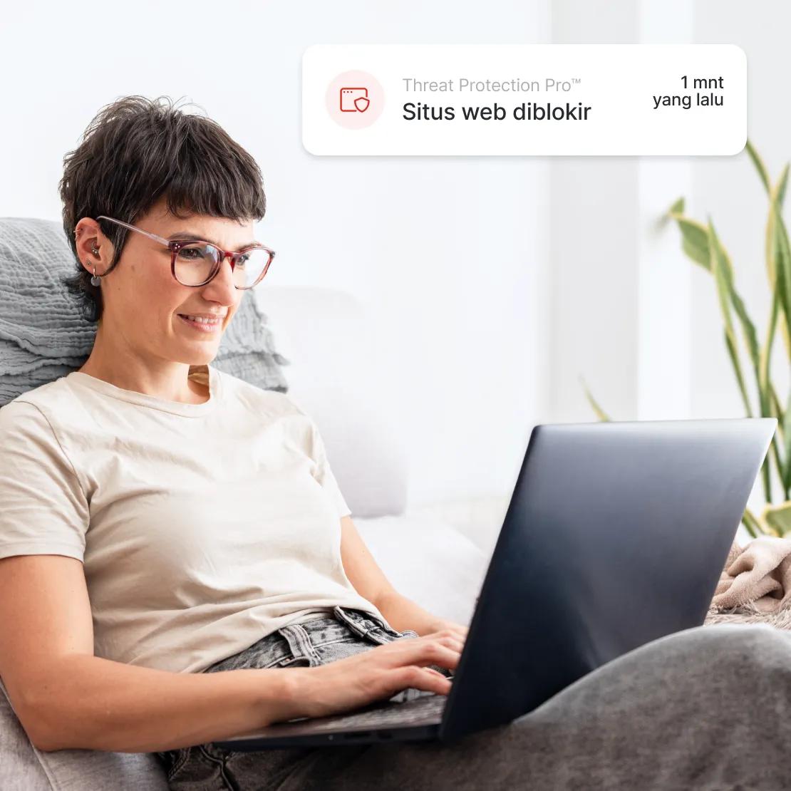 Wanita menikmati internet yang lebih aman karena Threat Protection Pro™ memblokir situs berbahaya.