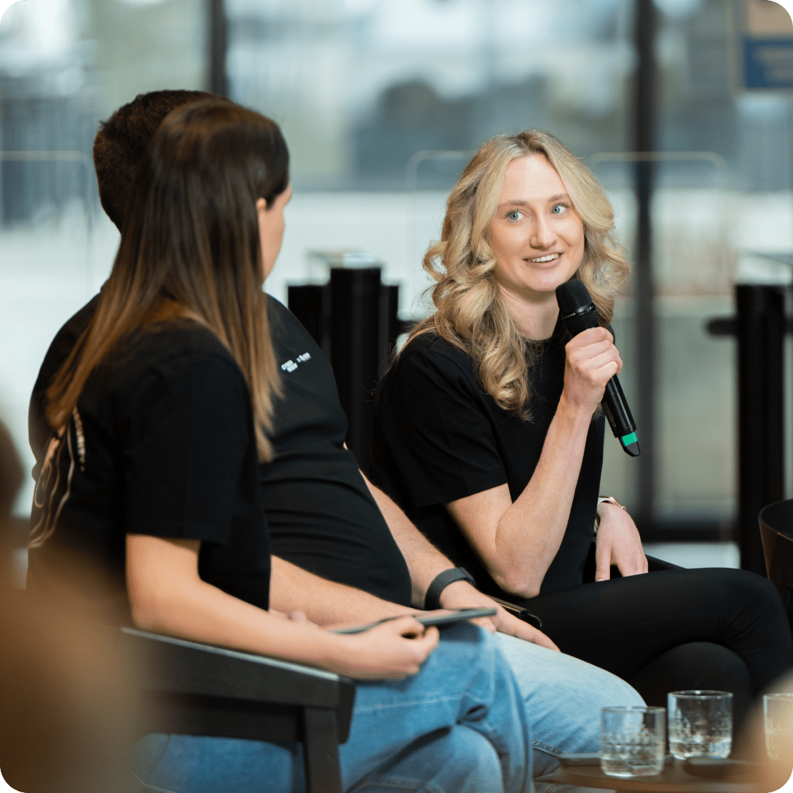 Una mujer hablando por un micrófono durante un evento de concienciación para empleados.