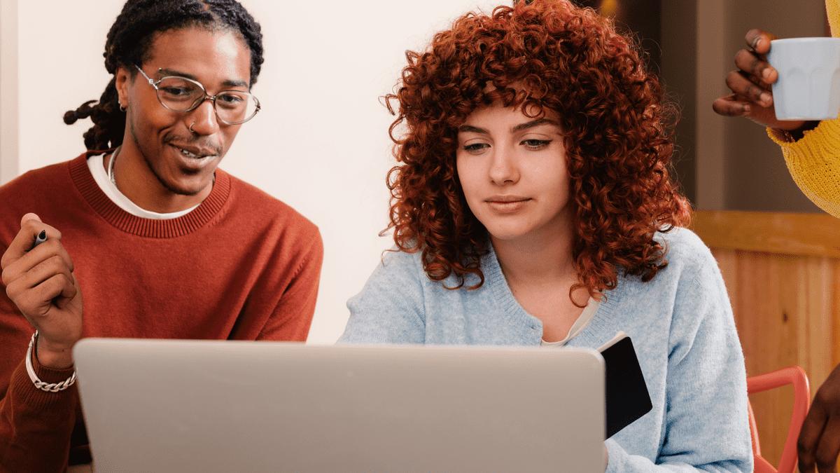 Two colleagues looking at a laptop together.