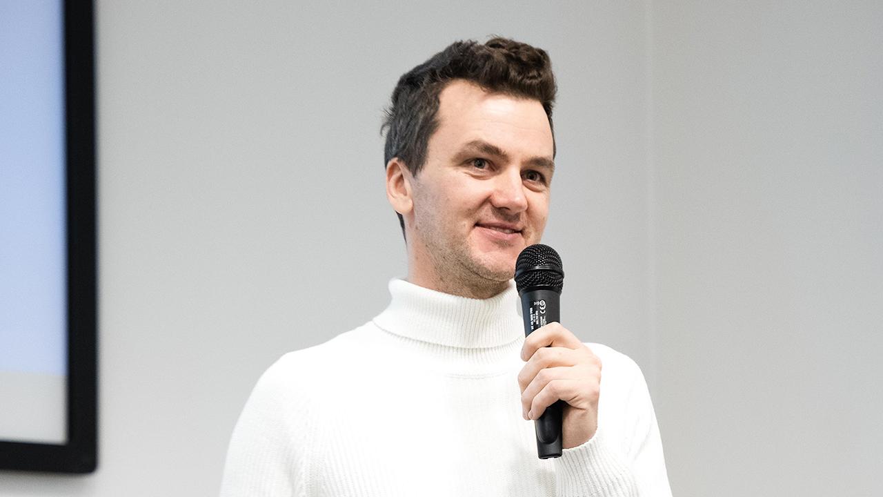 Marijus Briedis, CTO at NordVPN, holding a microphone while presenting at Nord Security Tech Days.