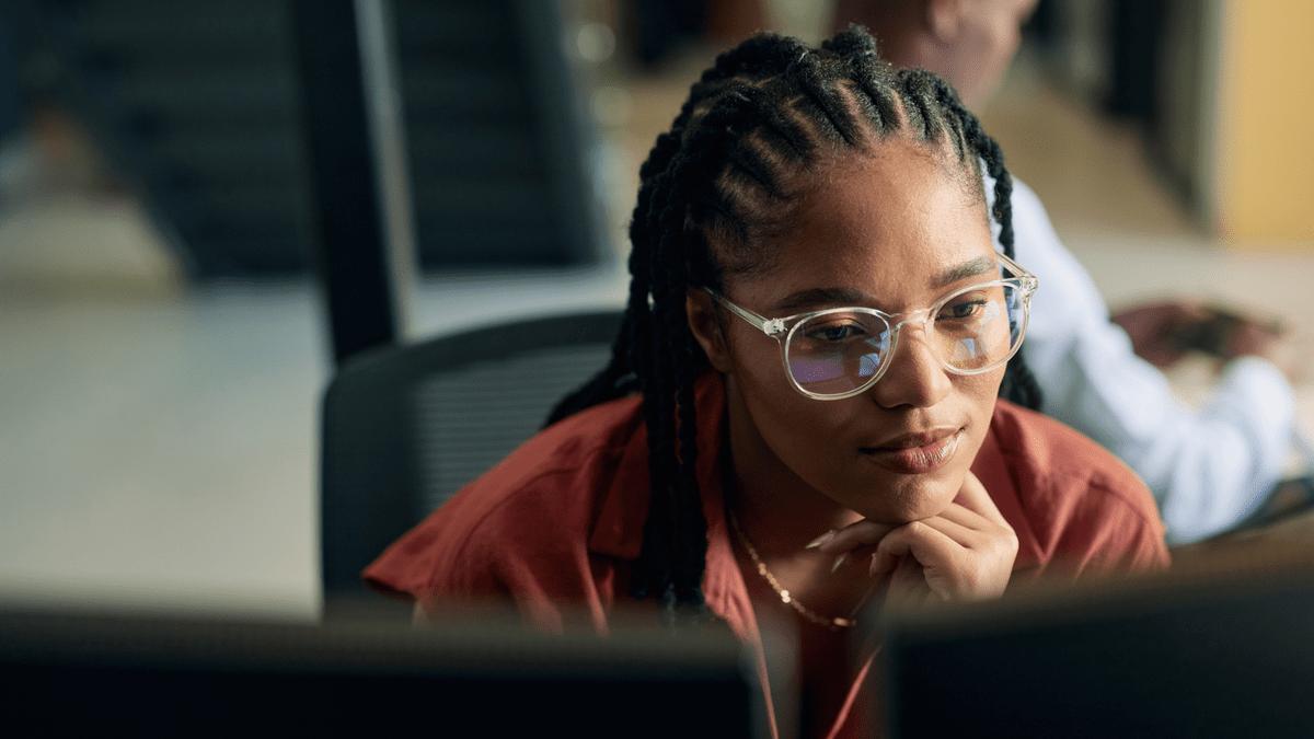 Developer looking at a monitor in an open-plan office.