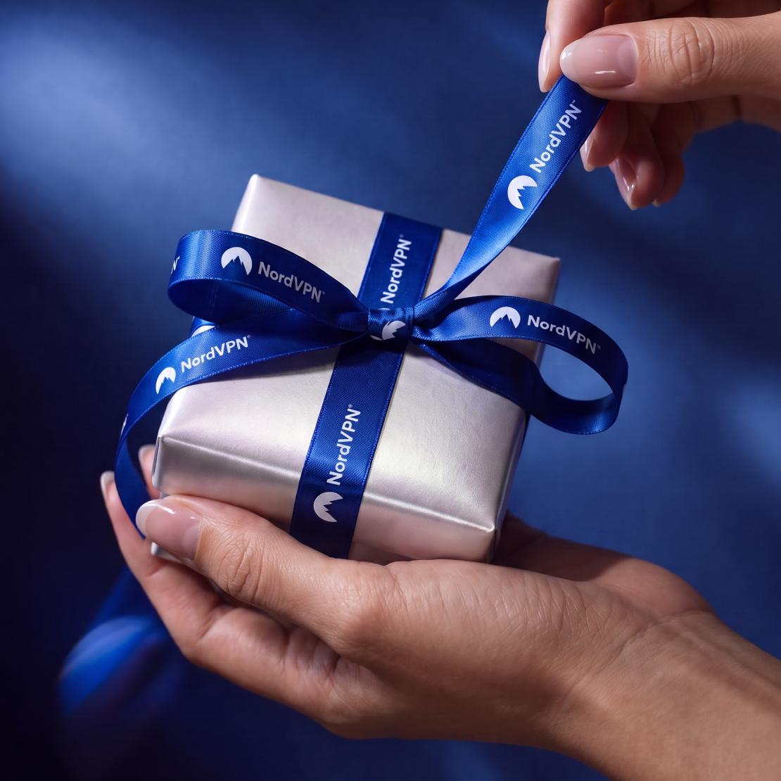 Mãos a segurar um presente de Natal da NordVPN.