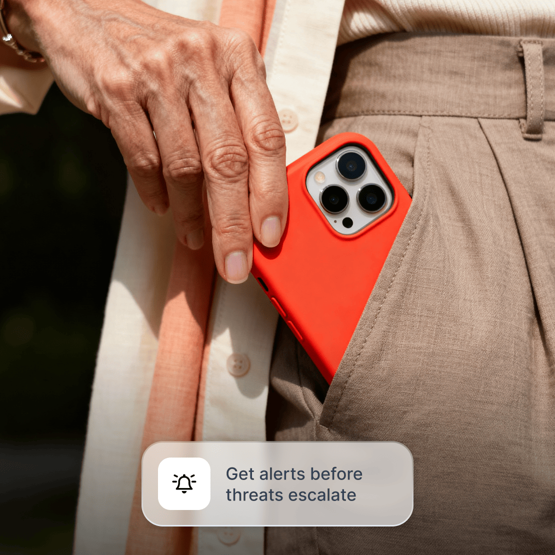 A person putting a smartphone in their pocket after checking Coveron’s malware breach alerts.