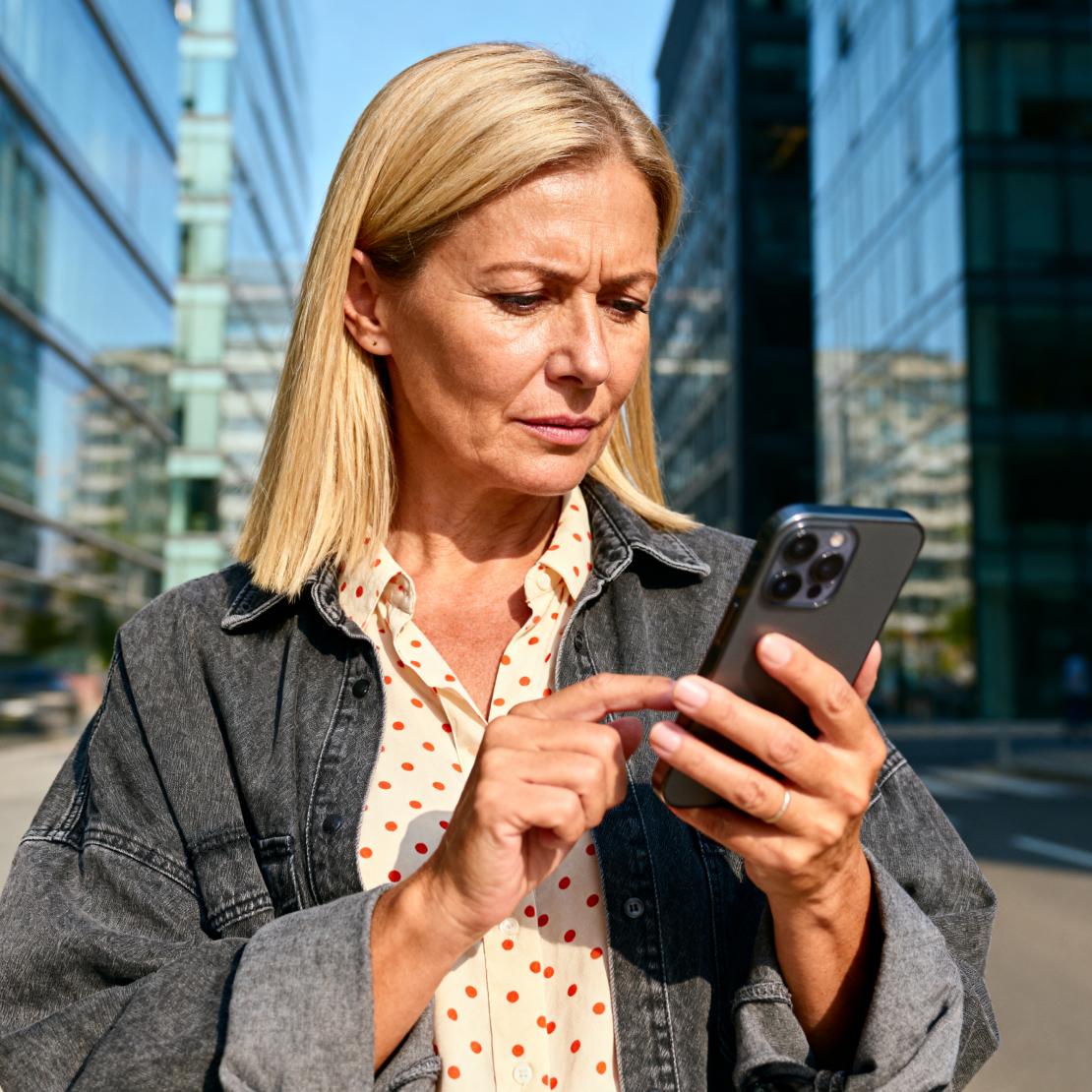 A woman checks her phone as leaked credentials put her accounts and identity at risk.