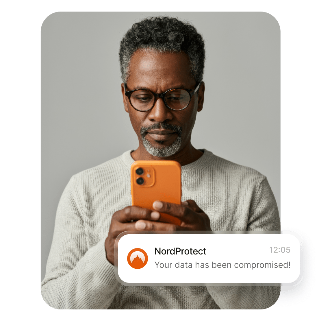  A man using a smartphone to read NordProtect’s alert about his data being compromised.