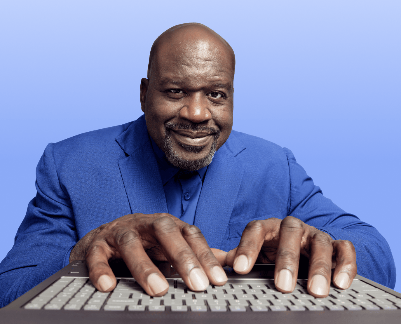Shaquille O'Neal using a laptop.