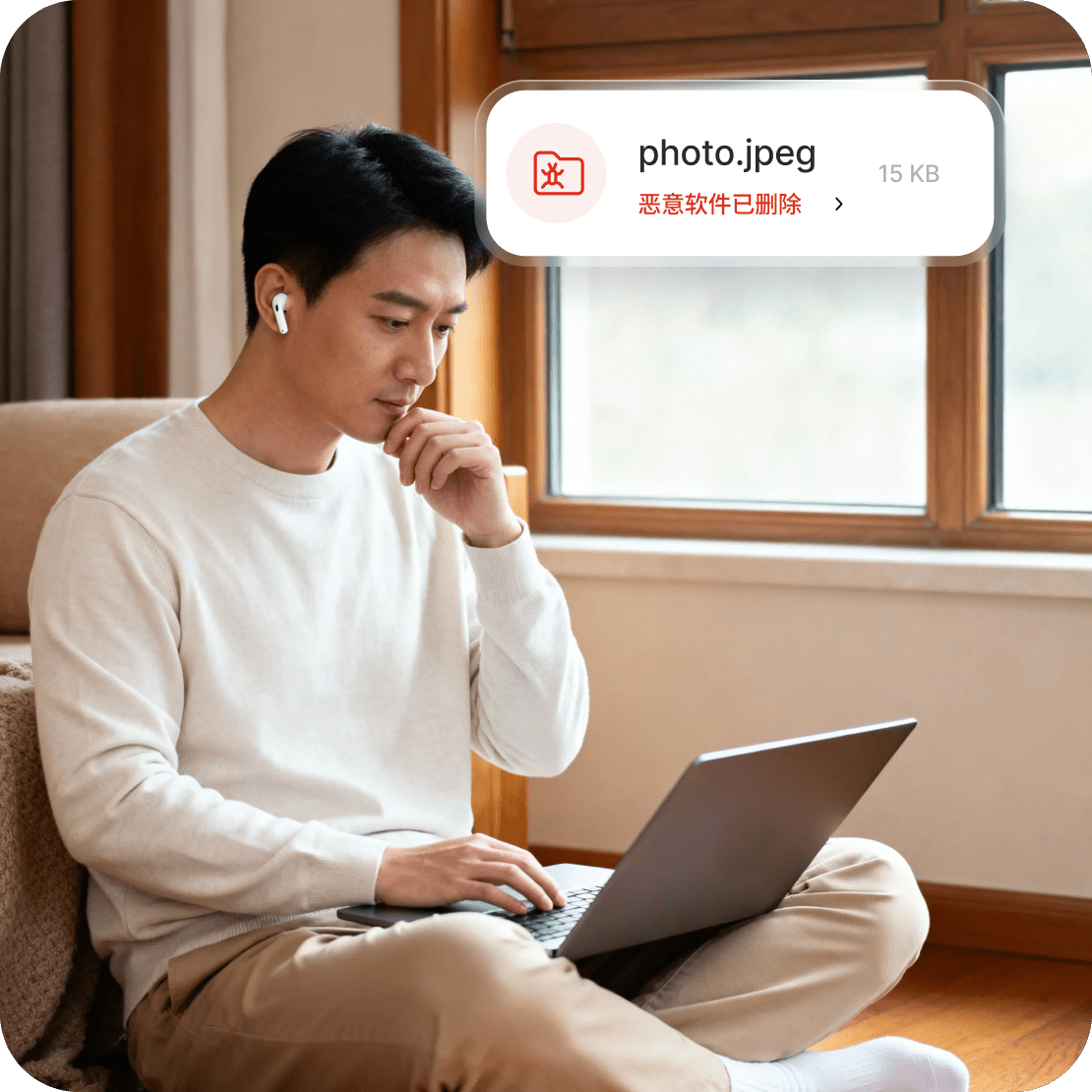 男子正在使用笔记本电脑，屏幕上显示着新一代杀毒工具的警报，提示因文件含有恶意软件已被删除。