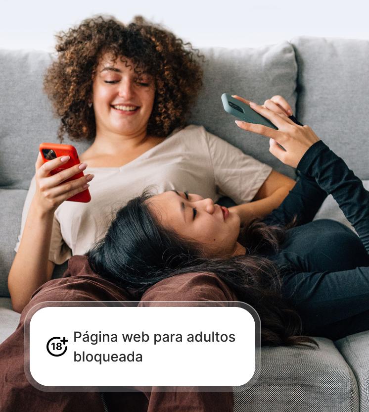 Dos mujeres usan sus teléfonos de forma segura gracias a la protección contra estafas y phishing, que bloquea las páginas para adultos.
