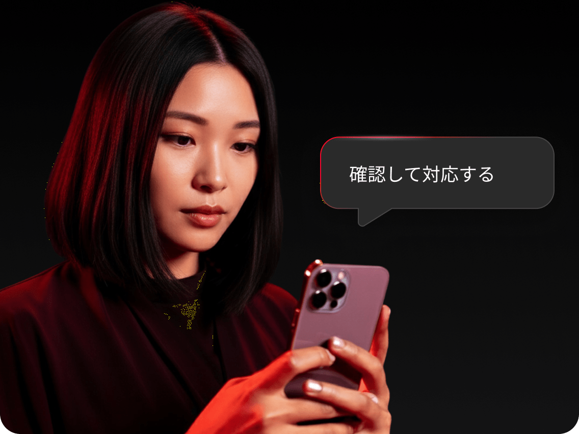 スマートフォンでダークウェブモニタリングのアラートを確認し、問題を解決しようとしている女性。