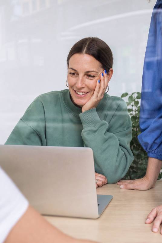 Nord Security employee smiling at her laptop in the office.